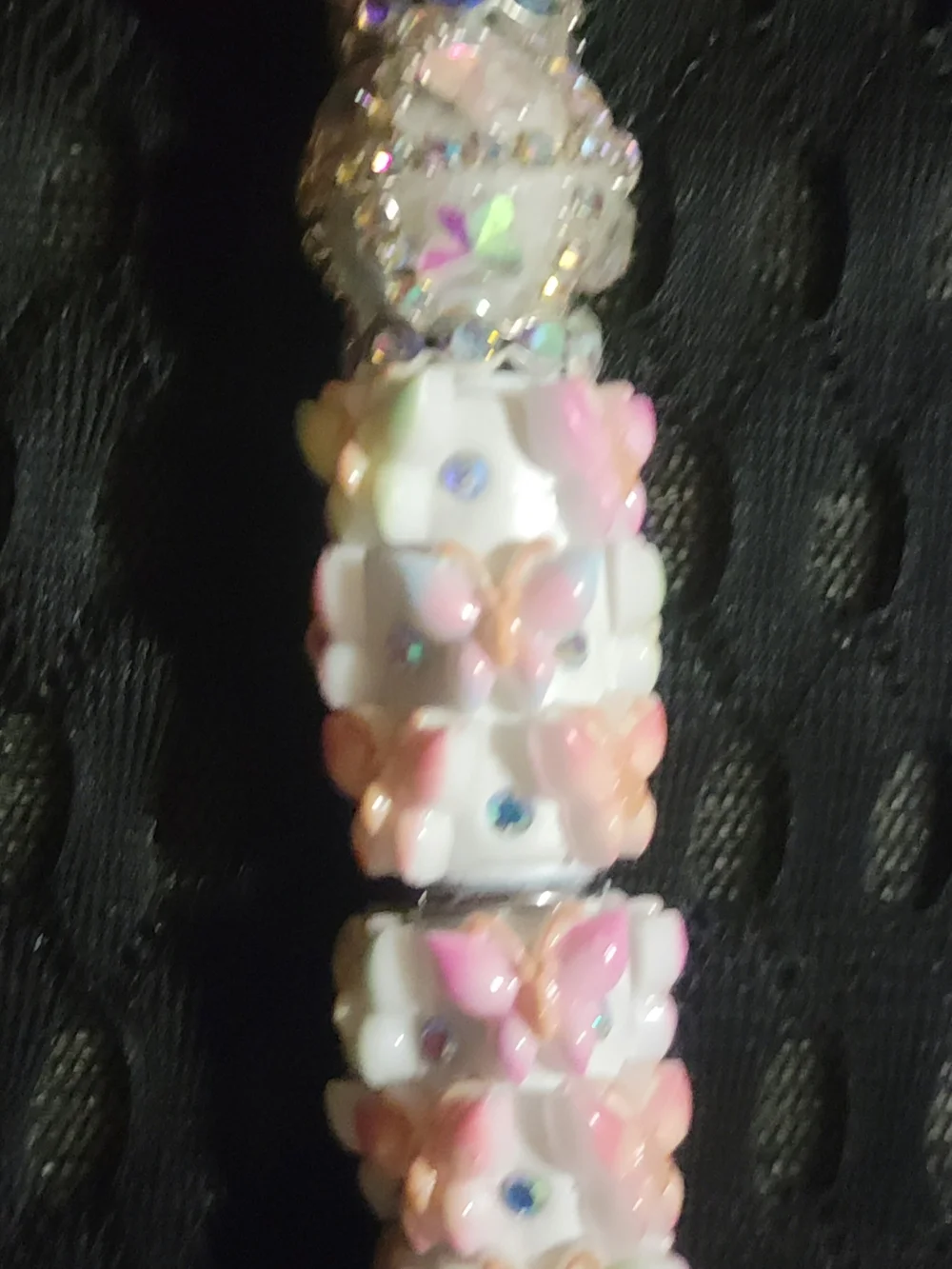 Handmade beaded ballpoint pen decorated with a pastel butterfly and floral theme